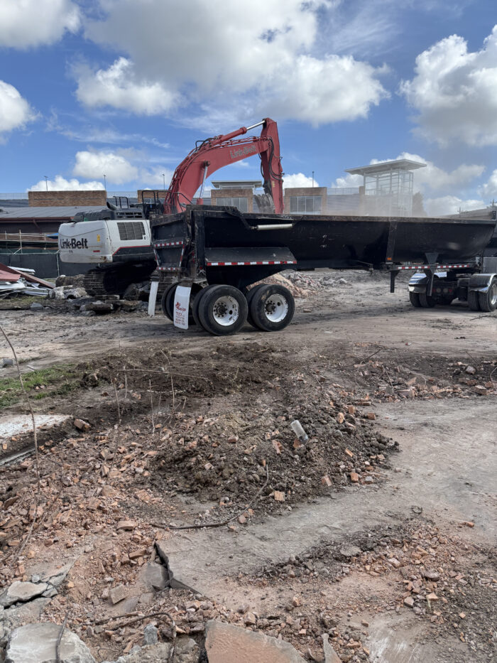 July 24 - Trackhoe moving concrete debris to a dump truck for disposal