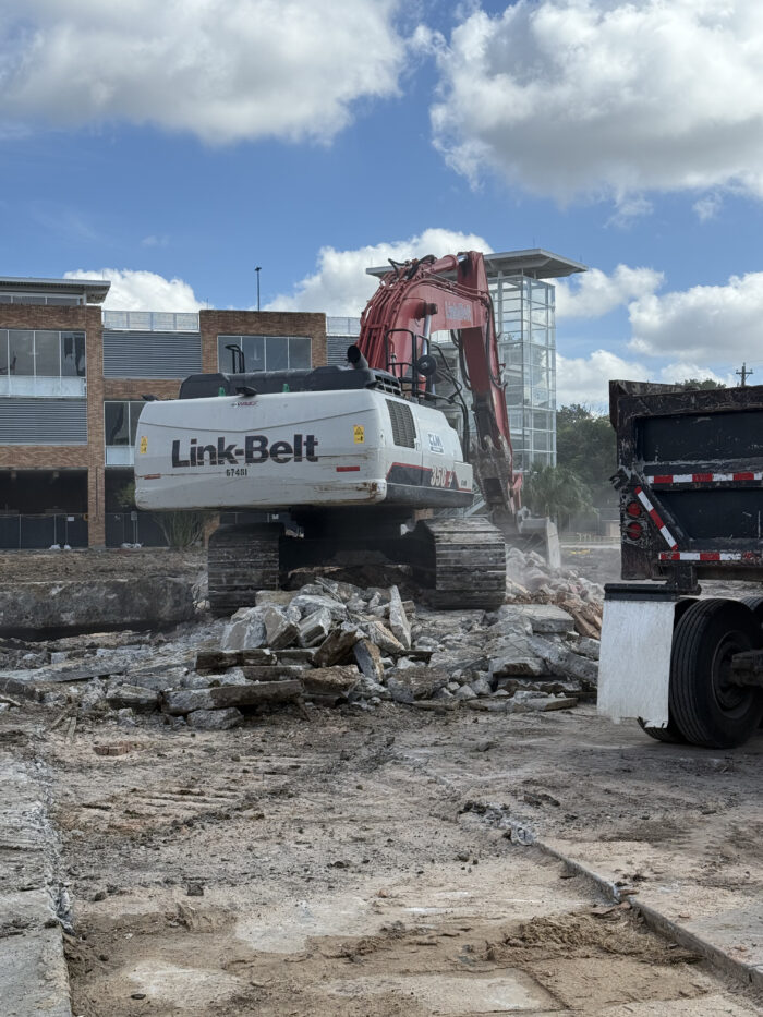 July 24 - Trackhoe moving concrete debris to a dump truck for disposal