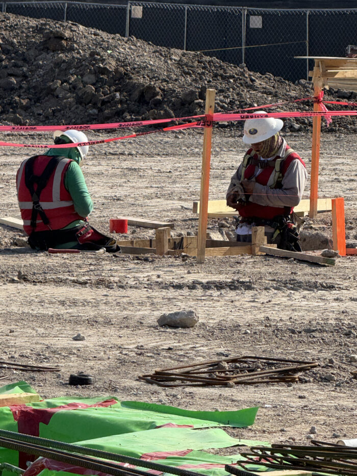 Workers creating the grade beams that will help support the building