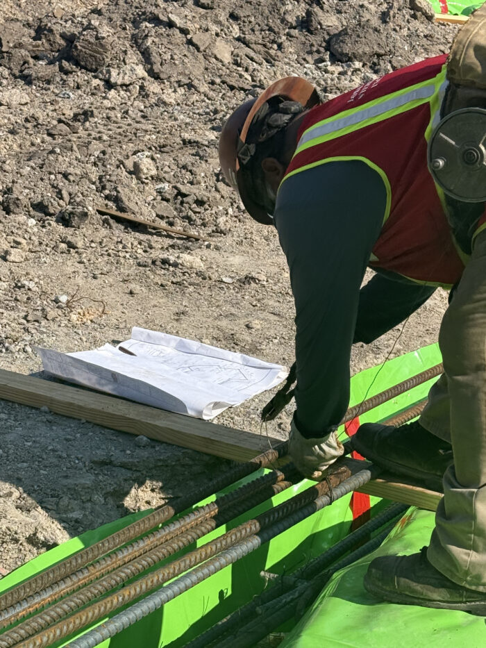 Workers creating the grade beams that will help support the building