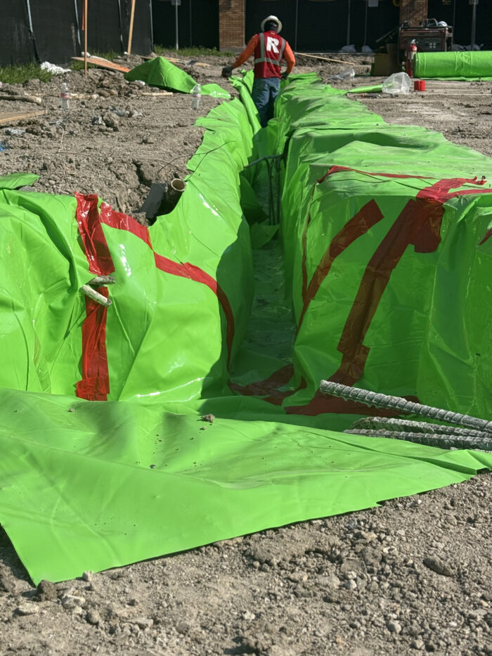 Workers creating the grade beams that will help support the building