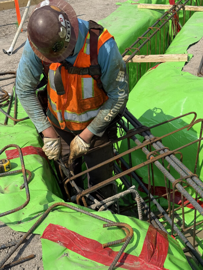 Workers creating the grade beams that will help support the building