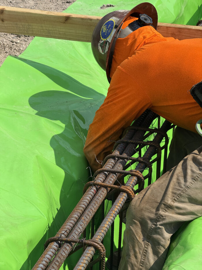 Workers creating the grade beams that will help support the building