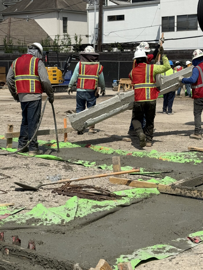 Construction workers use rebar and concrete to create grade beams to support the weight of the exterior walls
