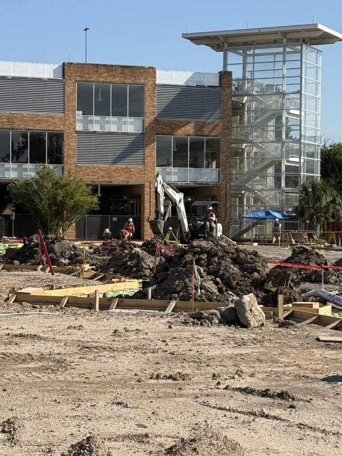 Construction workers dig trenches and use rebar and concrete to create grade beams to support the weight of the exterior walls